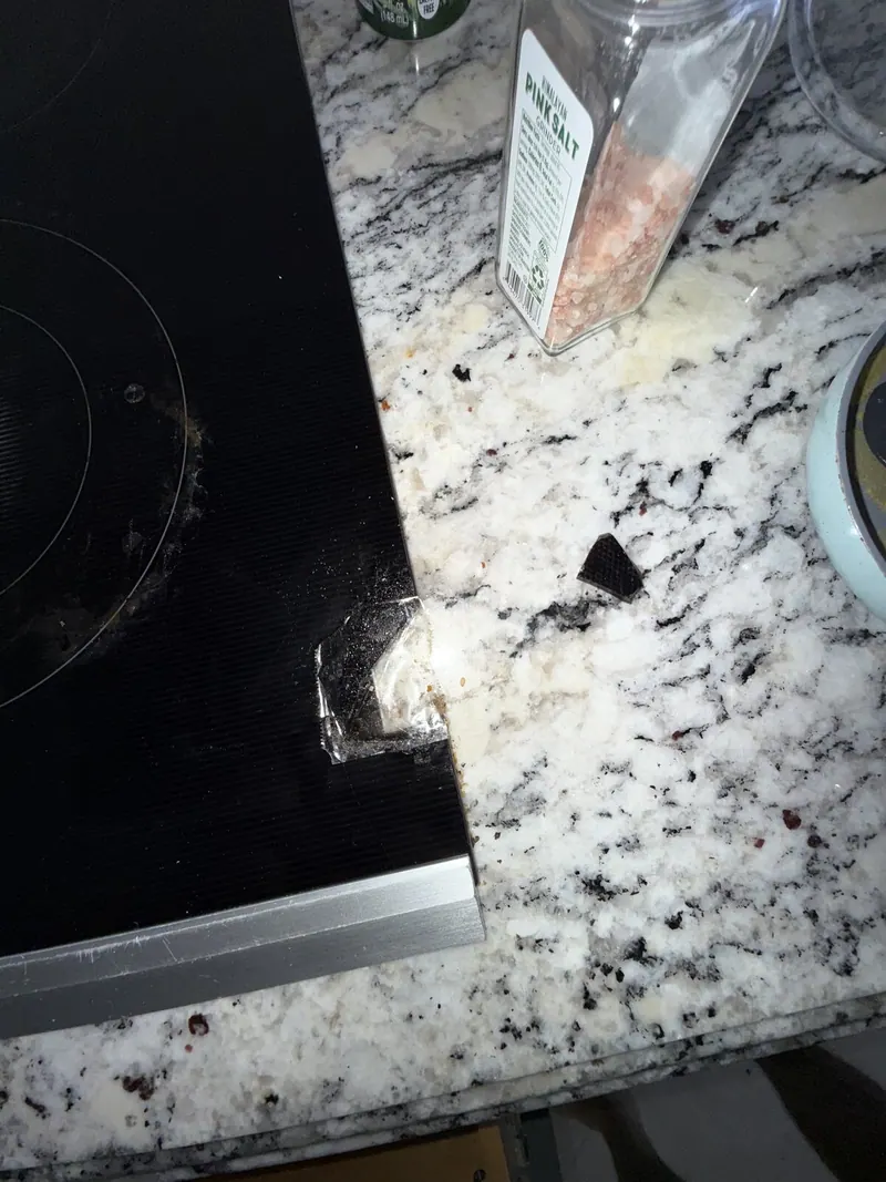 Cracked edge of the glass cooktop
