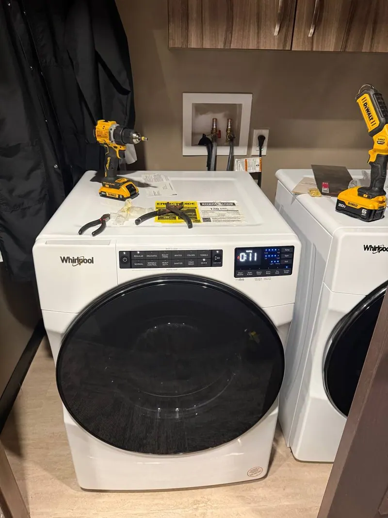 The washer reassembled in the laundry room, tools still on top