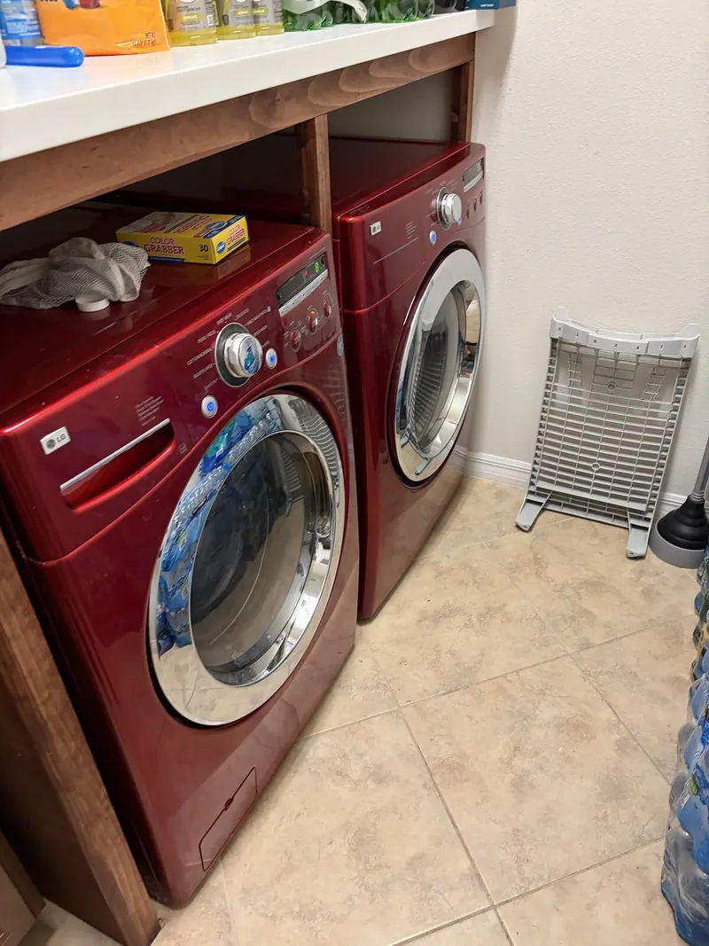 Red LG washer and dryer under a wooden counter