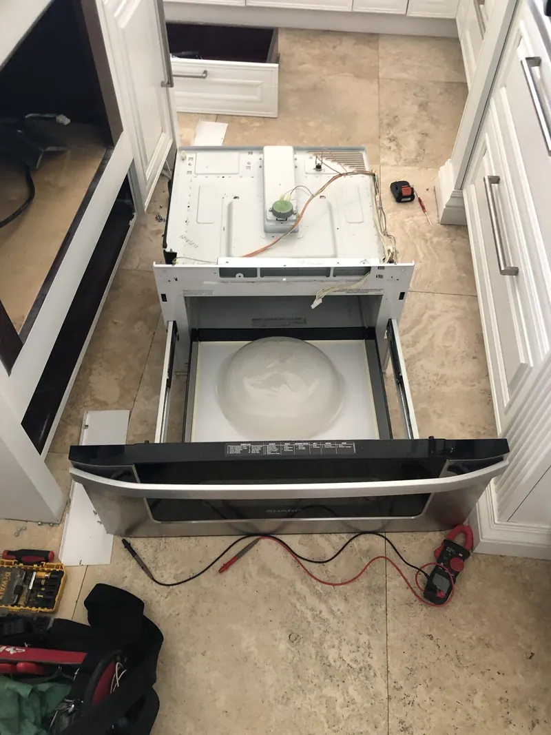 Microwave pulled out of the cabinet with the door open
