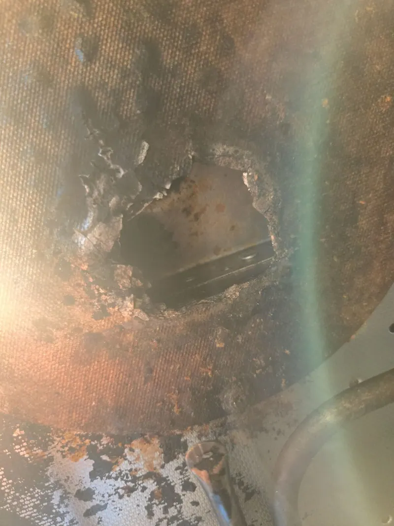 Hole burned through a metal panel inside the microwave