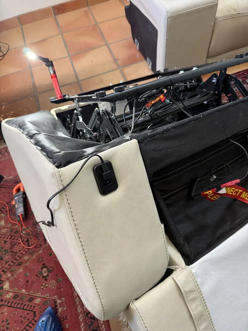 Back of the power reclining sofa opened up, mechanism and wiring exposed