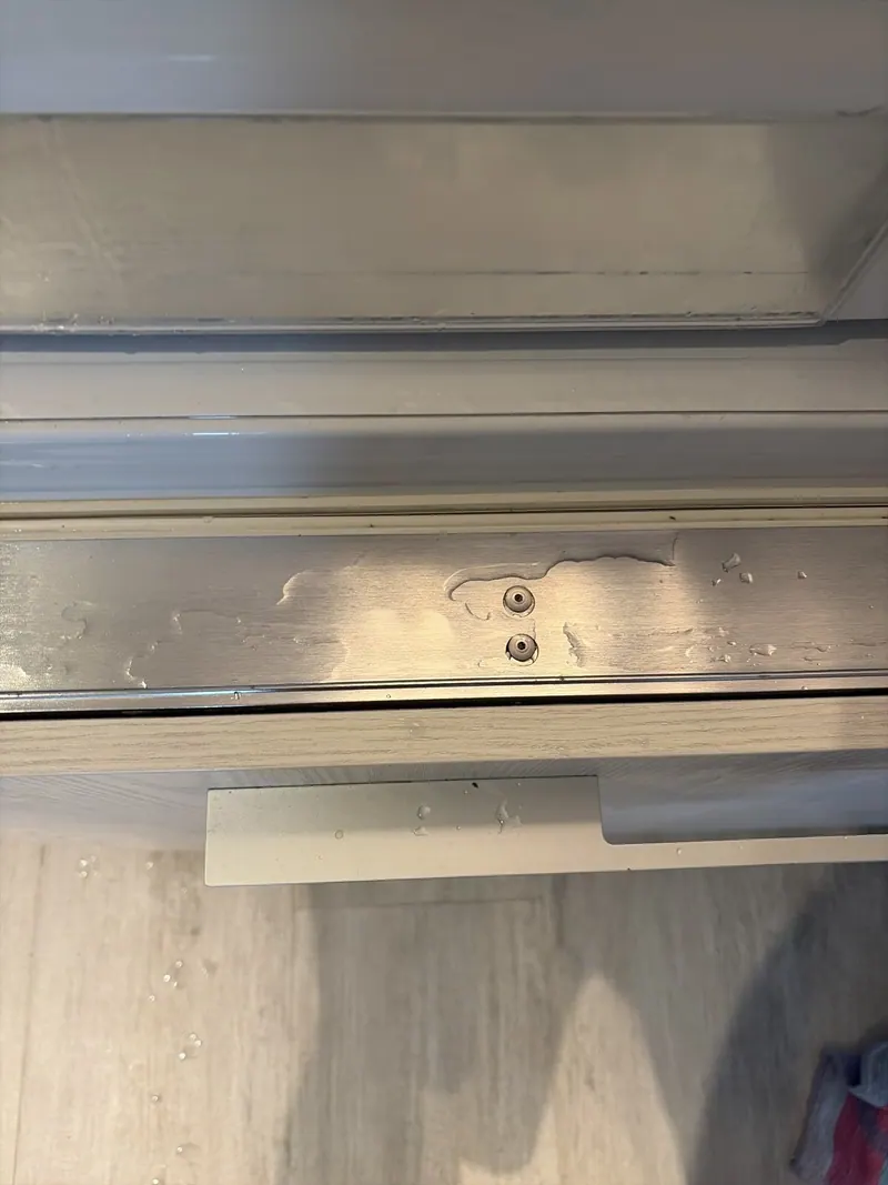 Water on the metal trim of a refrigerator drawer
