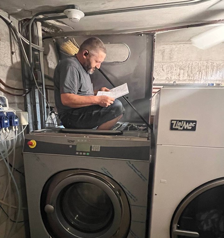 Berne Appliance Repair technician servicing a UniMac commercial washer in a South Florida laundry room