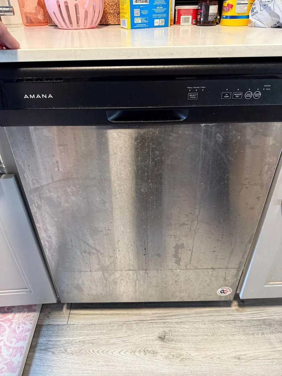 A stainless steel Amana dishwasher with a dirty front panel