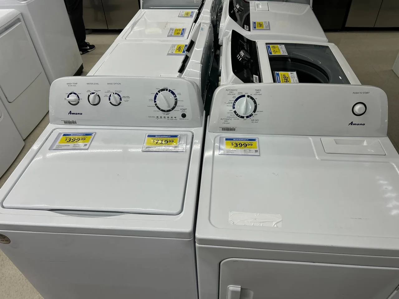 Two white Amana washing machines for sale in a store