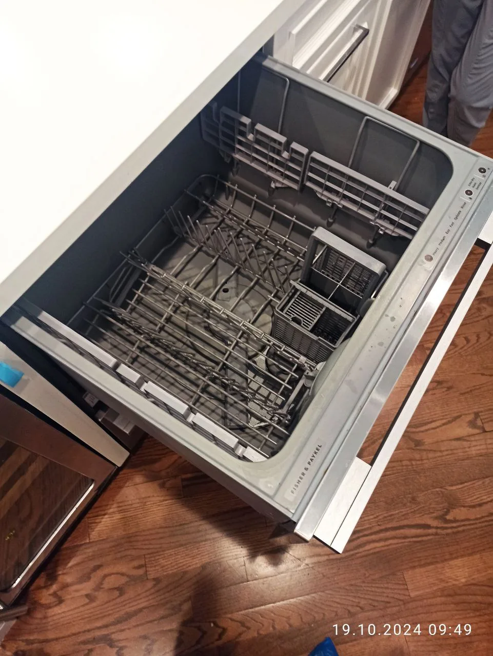 A Fisher & Paykel dishwasher with the drawer open, showing racks and controls