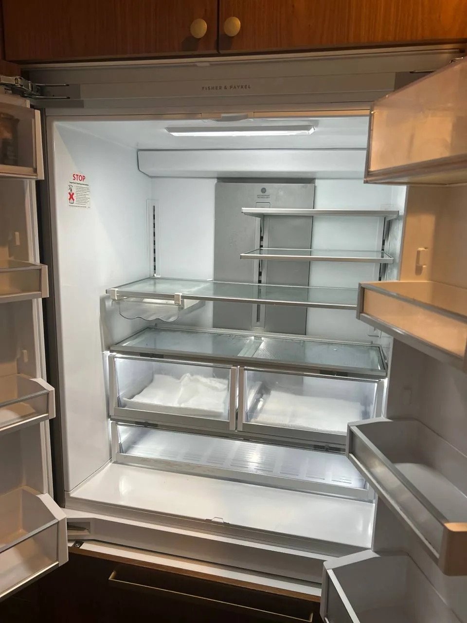 An empty Fisher & Paykel refrigerator with its doors open