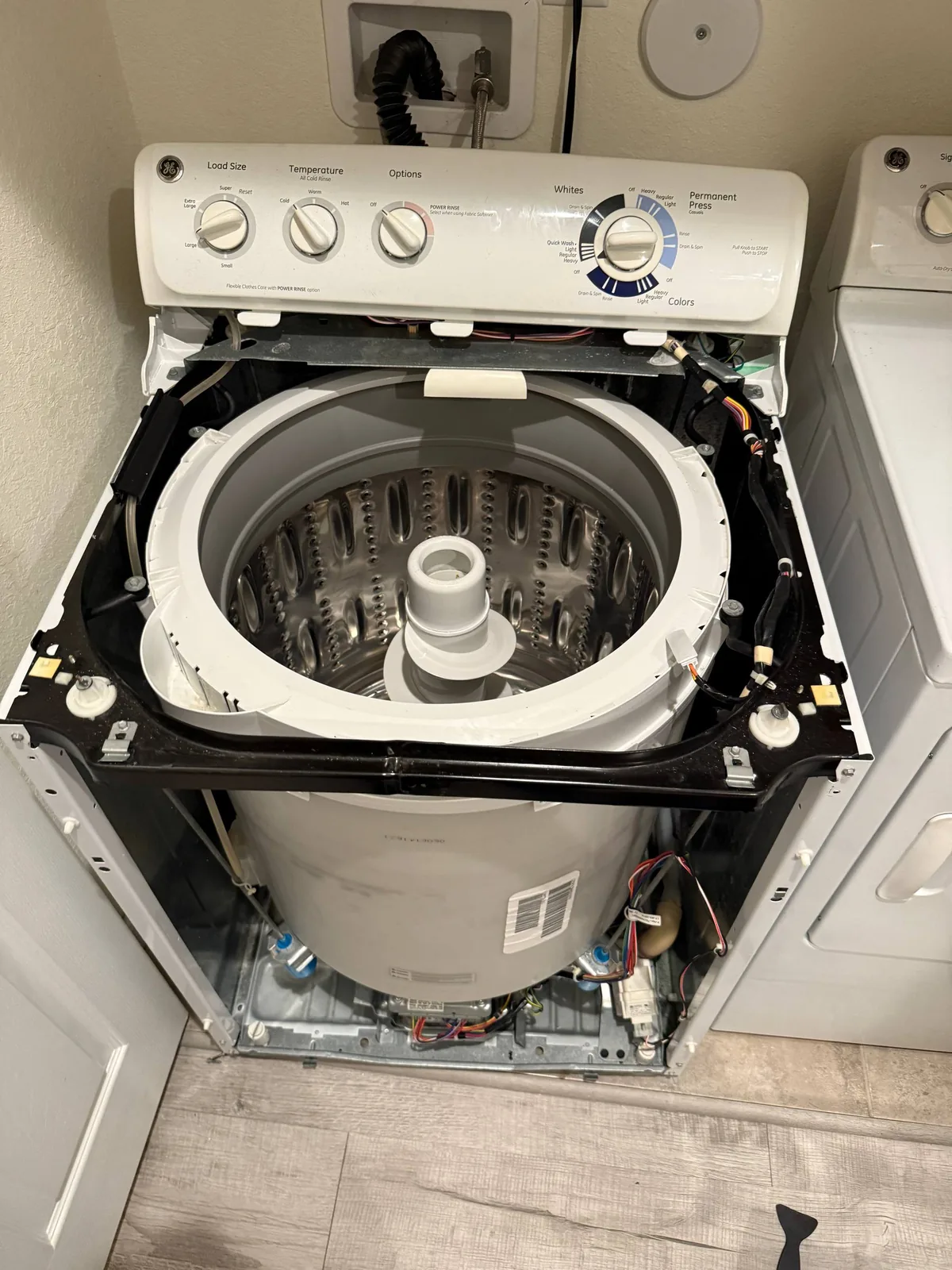 The interior of a GE top-load washing machine with its panels removed