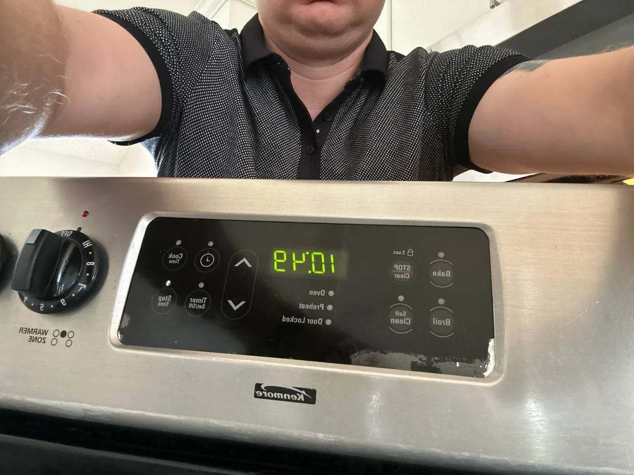 A technician over the control panel of a Kenmore oven