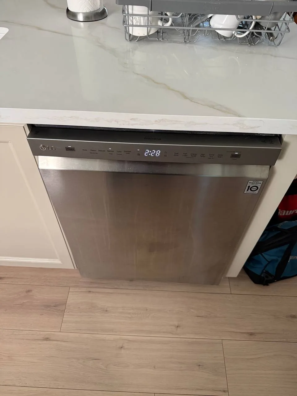 A stainless steel LG dishwasher is installed under a marble countertop