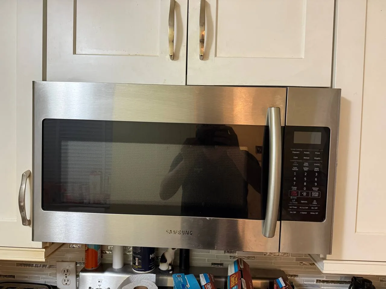 A Samsung over-the-range microwave is installed above kitchen cabinets