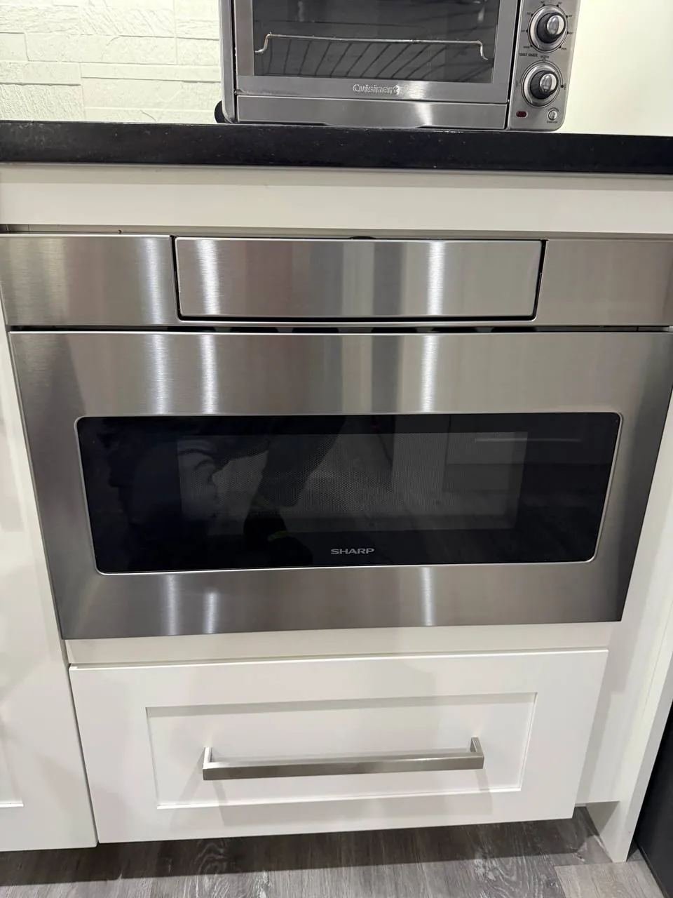 A Sharp microwave drawer and a Cuisinart toaster oven in a kitchen setting