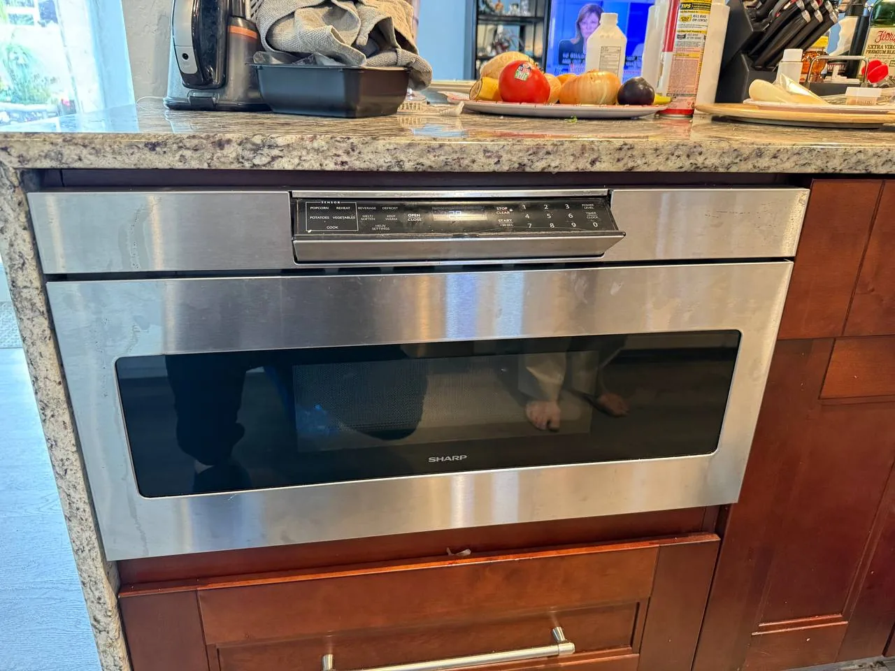 A built-in Sharp microwave in a kitchen counter