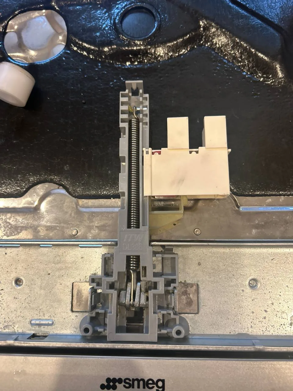 A Smeg dishwasher's internal component being repaired