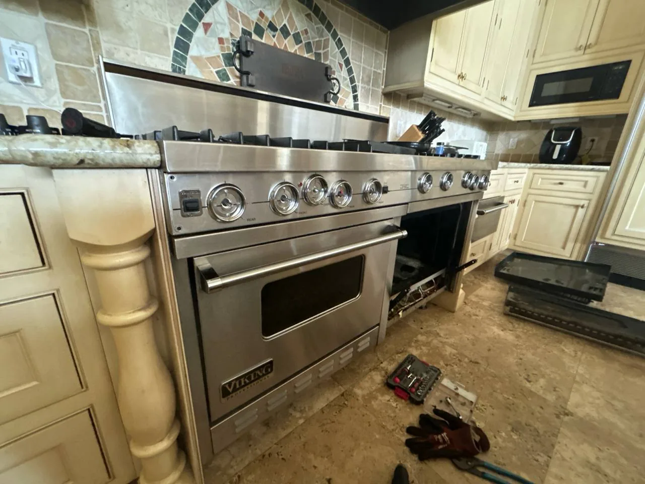 A Viking oven with tools on the floor in a kitchen