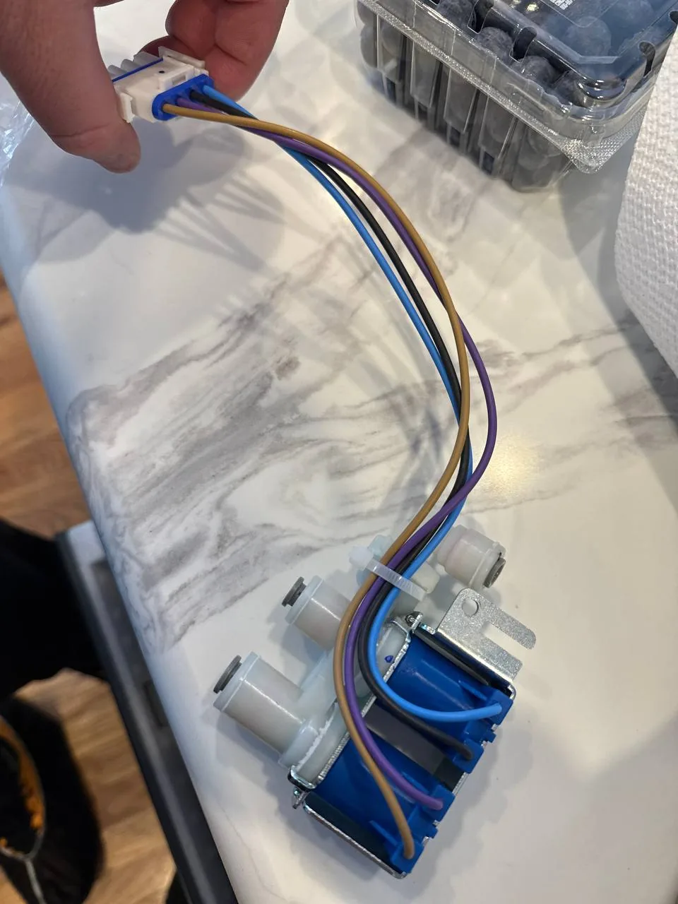 A solenoid water valve assembly with wiring on a countertop