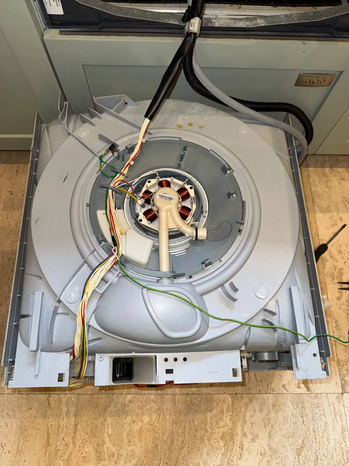 The internal components and wiring of a washer, suggesting it's being repaired