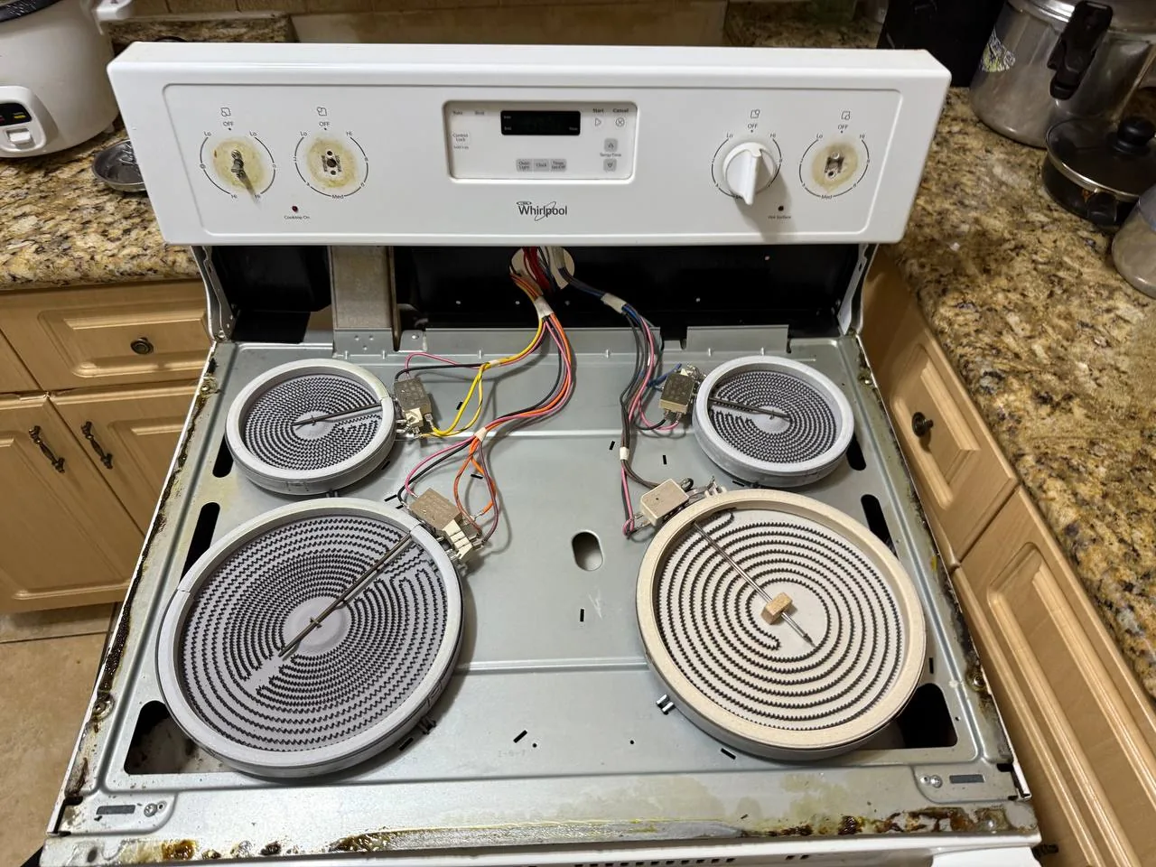 The interior of a Whirlpool oven with its heating elements exposed during a repair